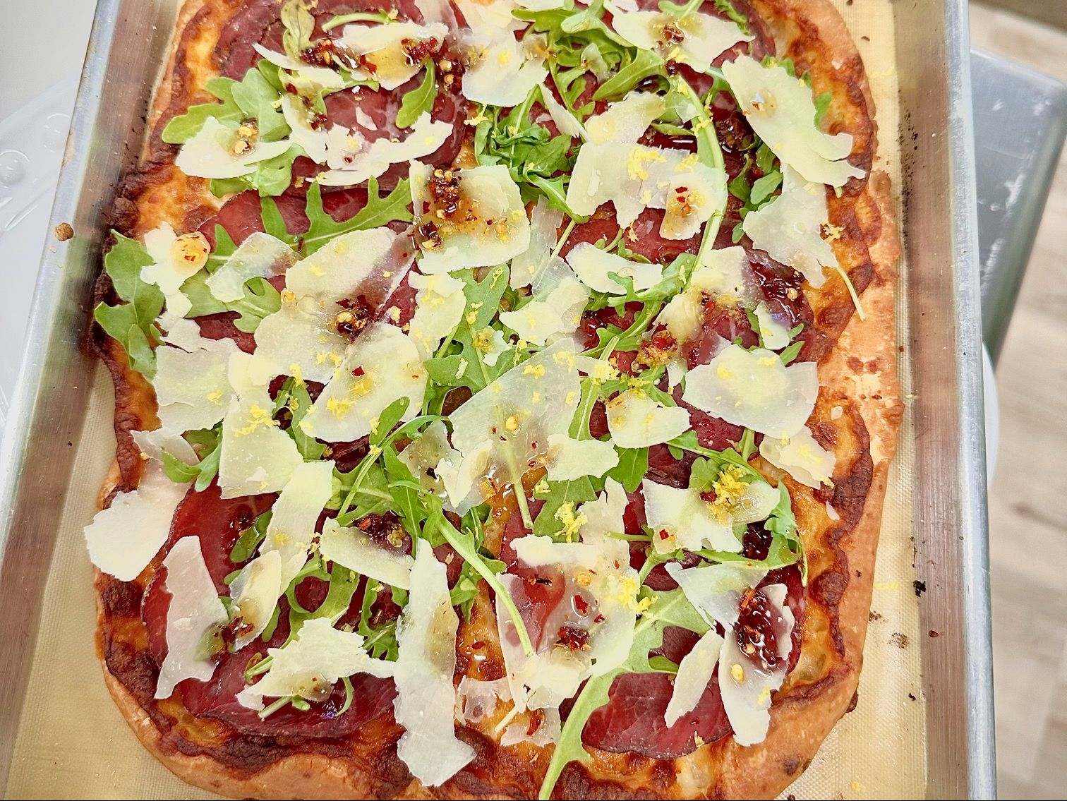 Bresaola pizzetta with arugula, parmigiano and lemon zest