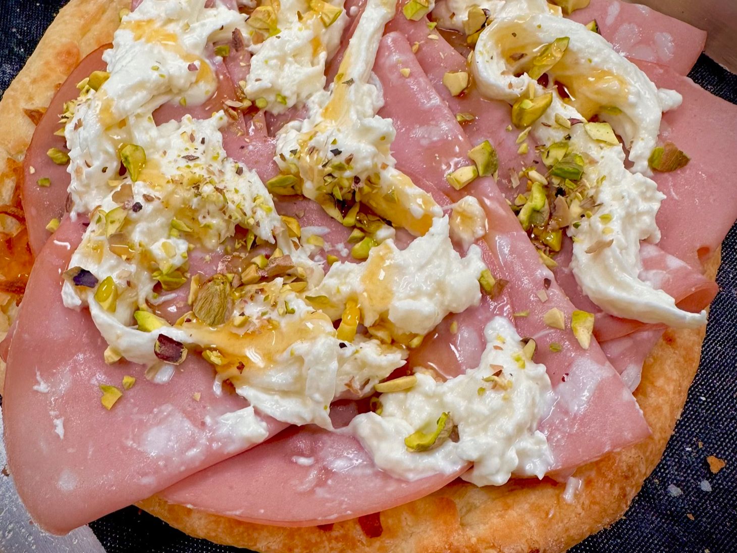Mortadella pizzetta with burrata, pistachios and spicy honey