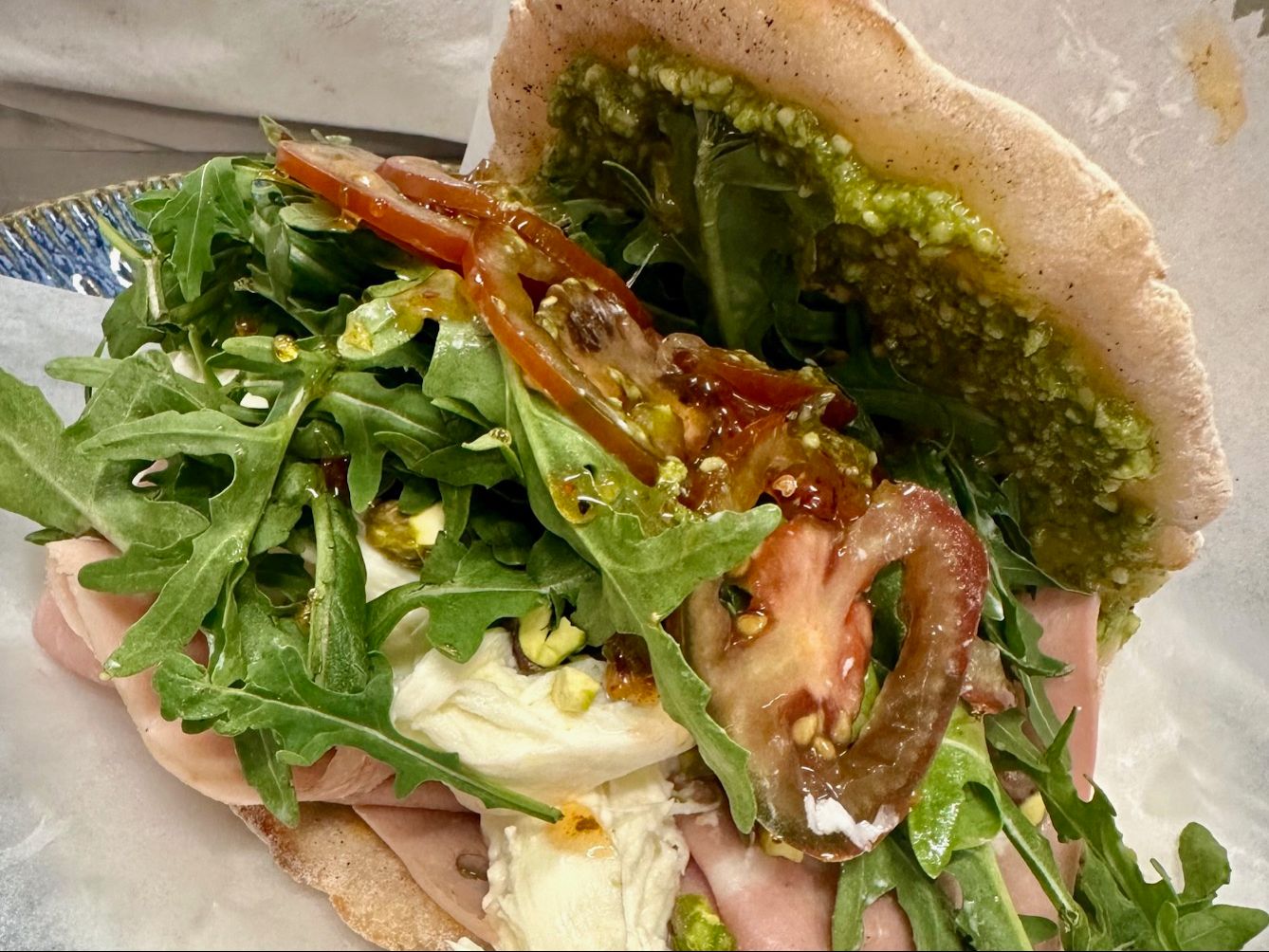 Mortadella pistachio burrata panino with arugula and tomato